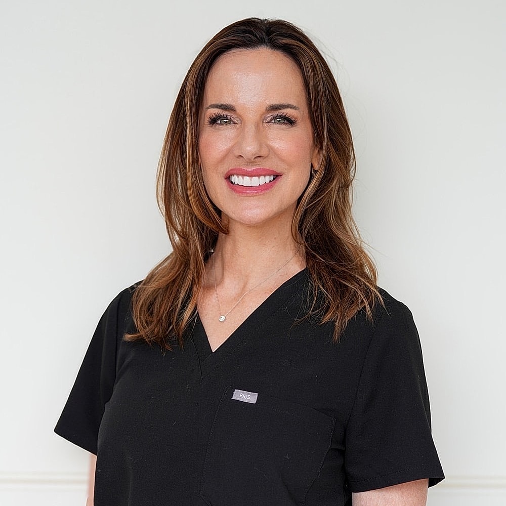 Smiling woman in black medical scrubs.