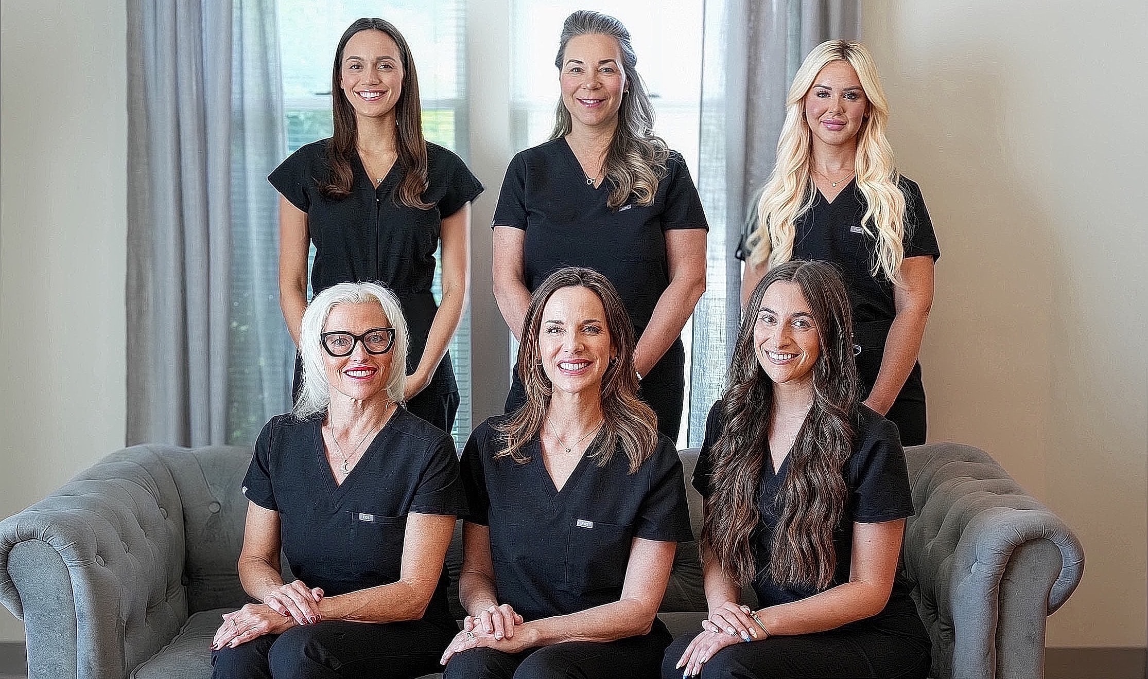 Health care team posing in black scrubs.