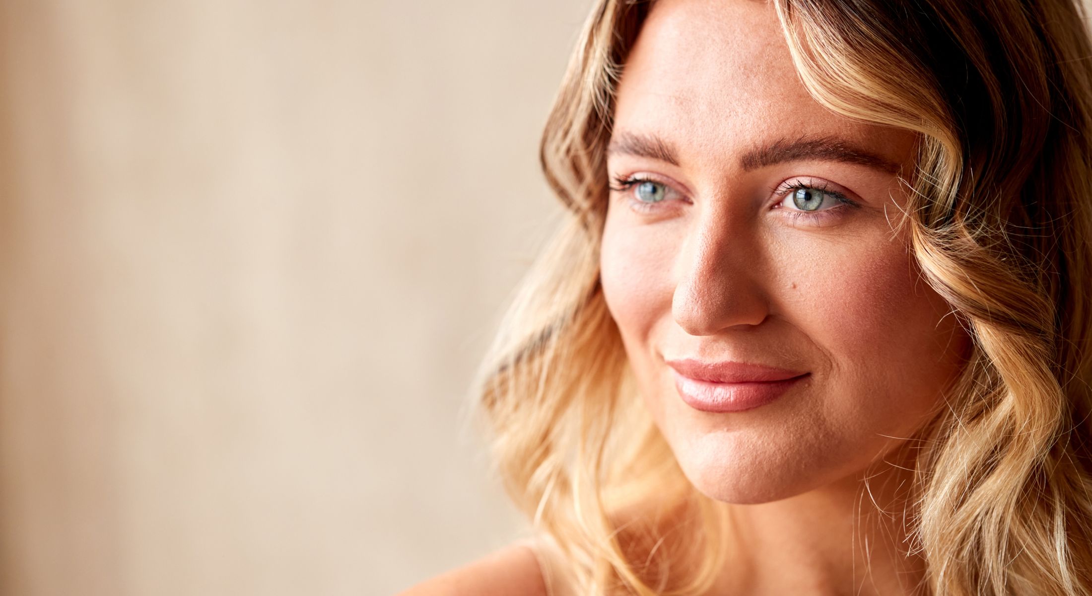 Smiling woman with wavy blonde hair.